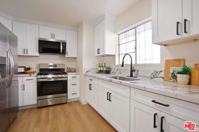 a dining room with furniture a potted plant and a kitchen view