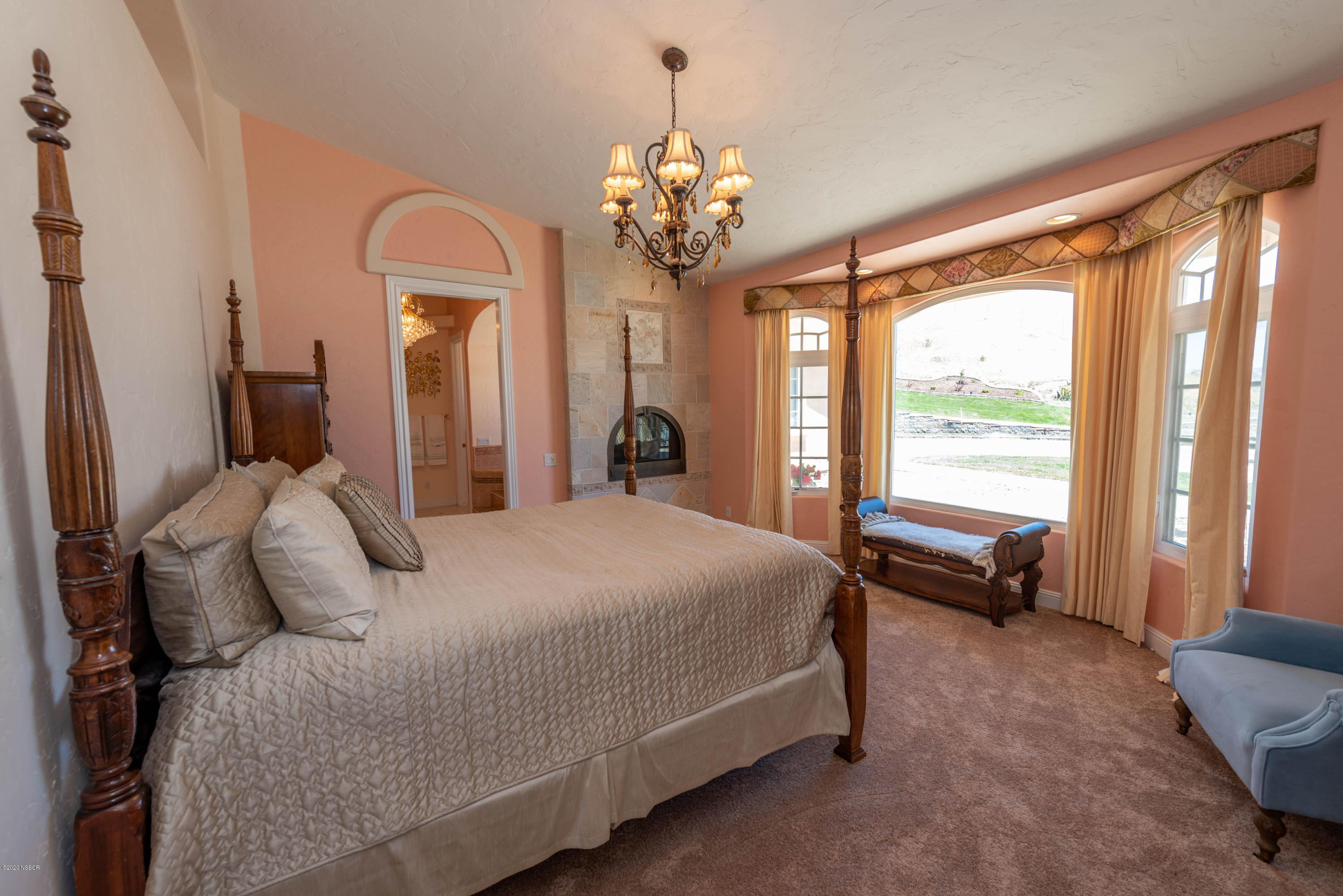 2610 Le Valley Road Lompoc, CA 93436 - Photo 15 of 36 a bedroom with a large bed and a chandelier