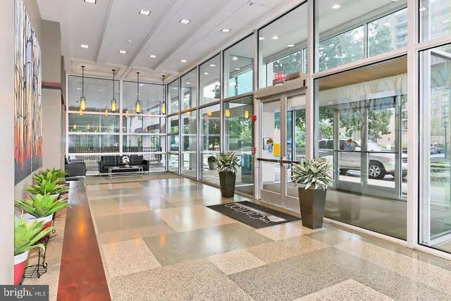 a view of a lobby with a floor to ceiling window and wooden floor