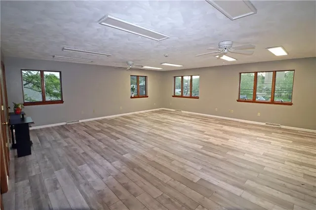 an empty room with wooden floor and windows