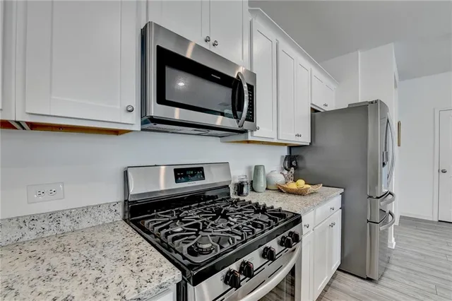 a kitchen with stainless steel appliances granite countertop a stove and a microwave