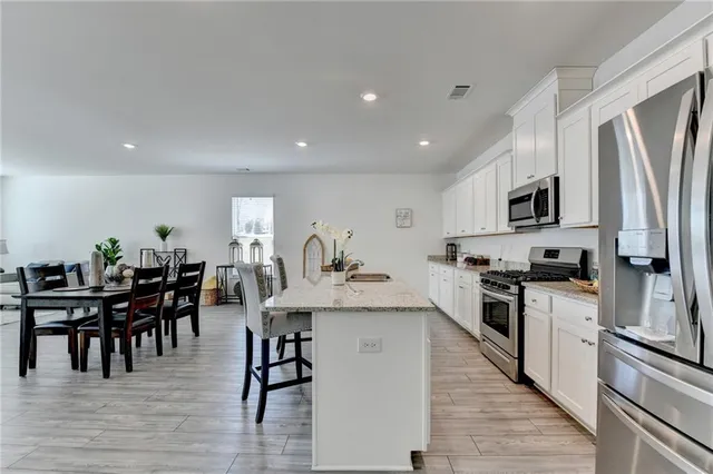 a large kitchen with cabinets table and chairs