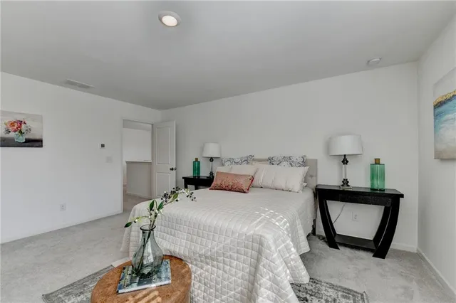 a bedroom with a bed a mirror and lamp on desk