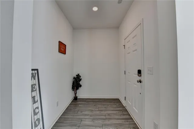 a view of a hallway with wooden floor and staircase