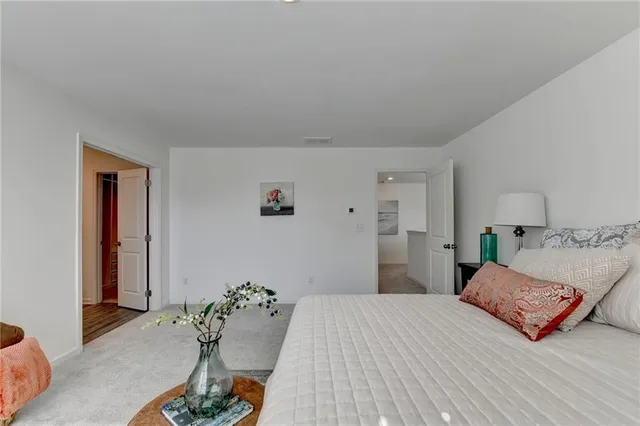 a bedroom with a bed and painting on the wall