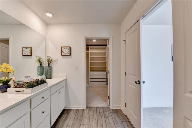 a hallway with white cabinets and wooden floor