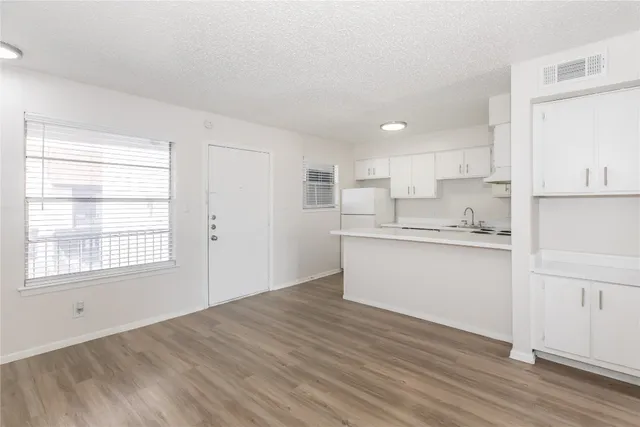 a kitchen with granite countertop white cabinets and wooden floor