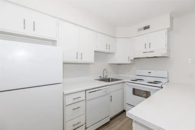 a kitchen with white cabinets and white appliances
