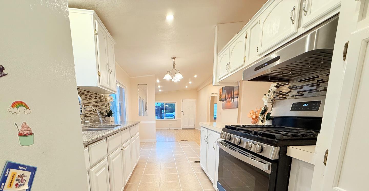 411 Lewis Road, Unit 335 San Jose, CA 95111 - Photo 11 of 27 a kitchen with granite countertop a stove and a white cabinets