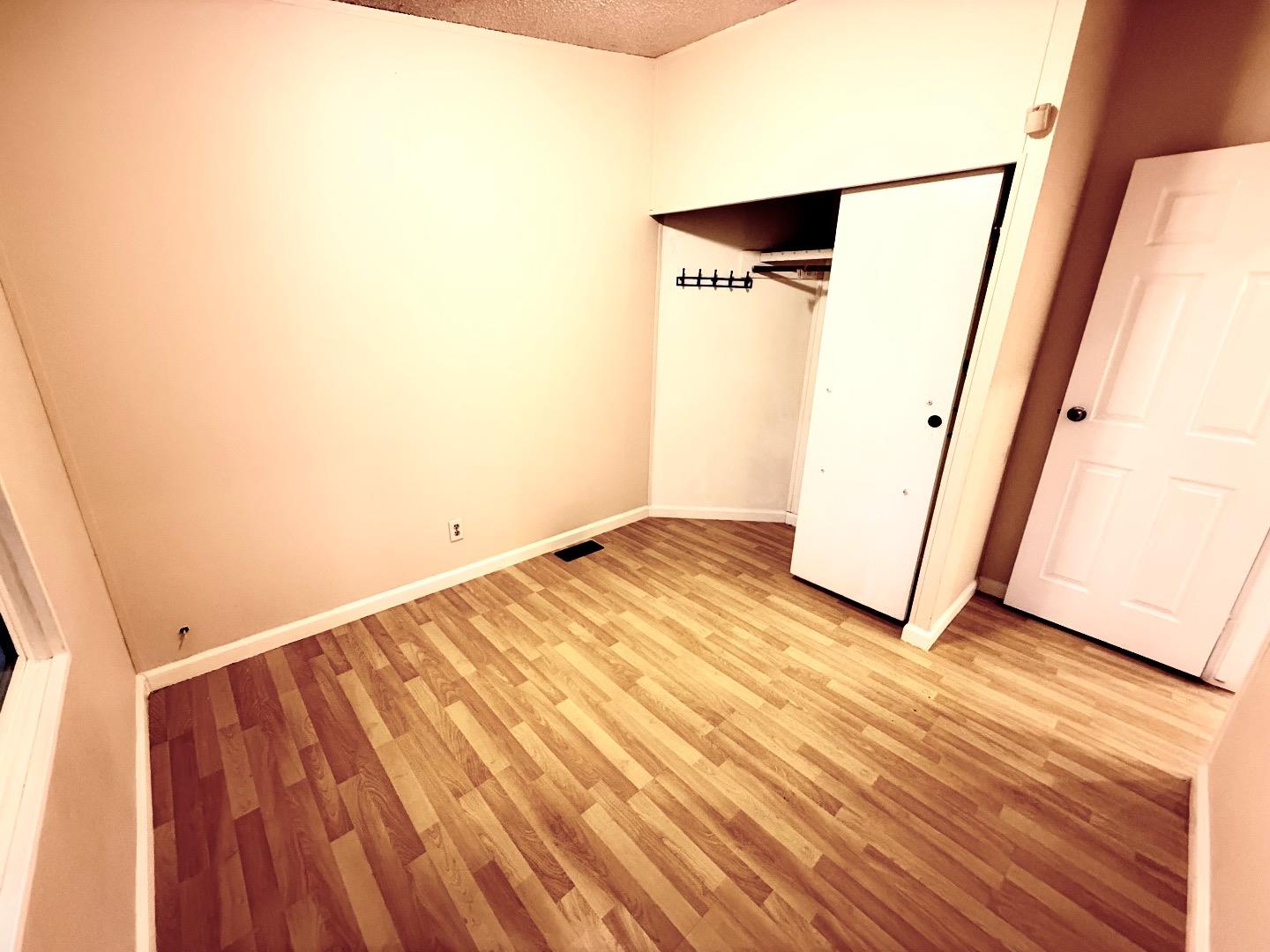 411 Lewis Road, Unit 335 San Jose, CA 95111 - Photo 17 of 27 a view of an empty room with wooden floor and a window