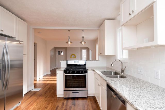 a kitchen with stainless steel appliances granite countertop a sink stove and refrigerator