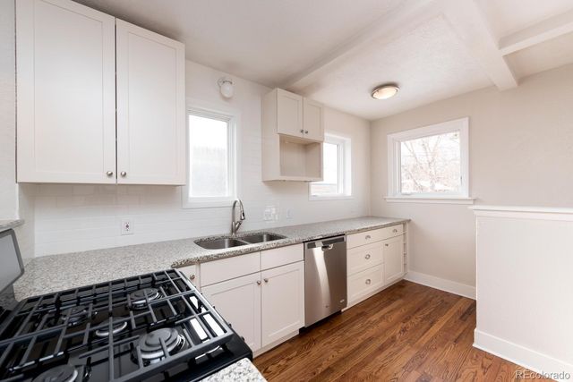 a kitchen with sink stove and cabinets