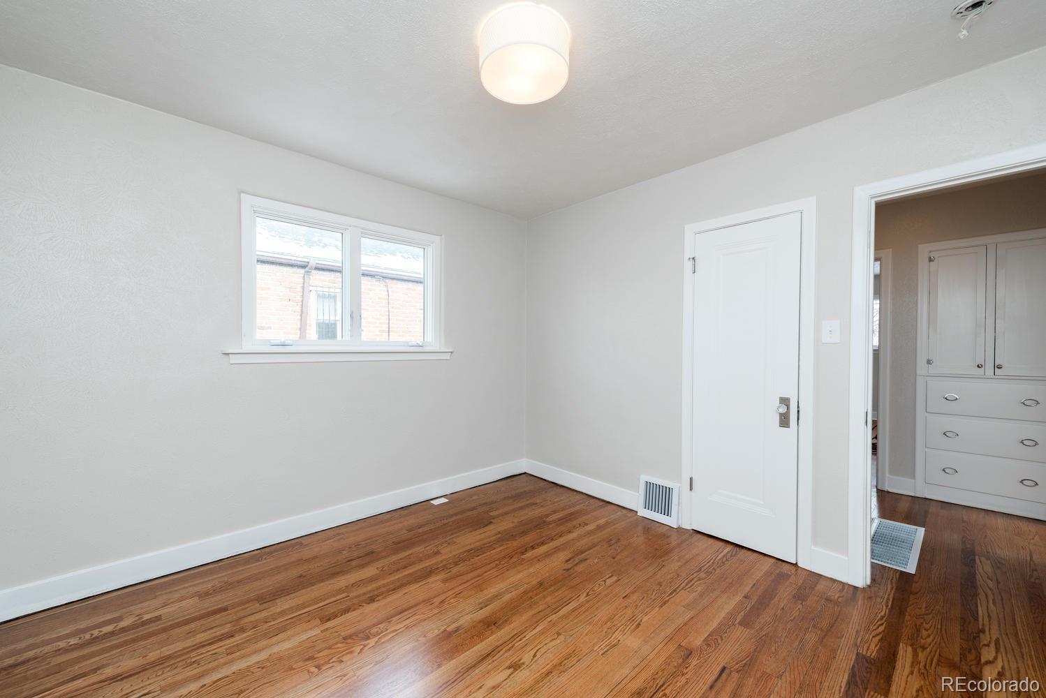 3527 Monroe Street Denver, CO 80205 - Photo 24 of 29 an empty room with wooden floor and windows