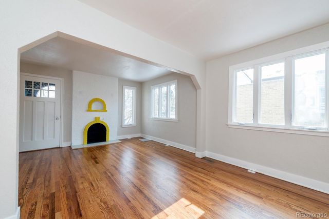 a view of a livingroom with wooden floor and window