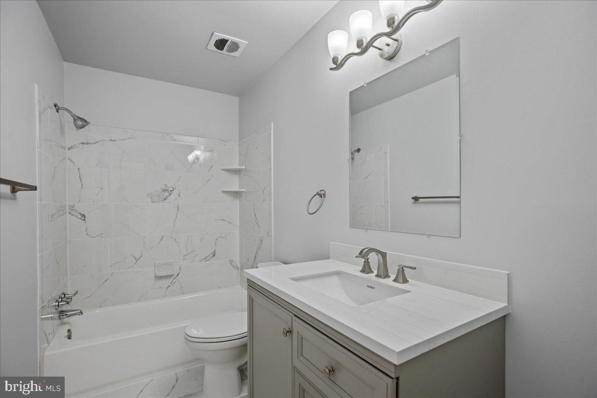 4227 Kinmount Road Lanham, MD 20706 - Photo 12 of 27 a bathroom with a sink a toilet a mirror and shower