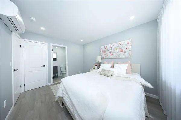 a bedroom with a large bed and a chandelier