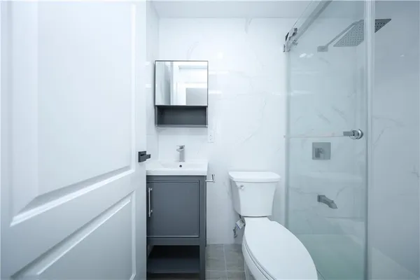 a bathroom with a toilet a sink a mirror and vanity