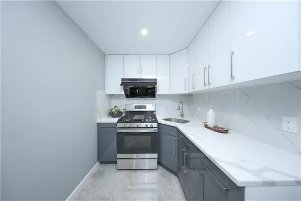 a kitchen with stainless steel appliances a sink a stove a microwave and cabinets