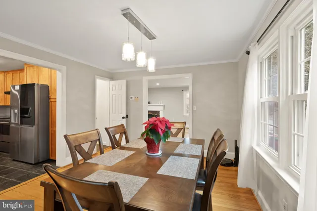 a living room with stainless steel appliances granite countertop furniture wooden floor and a kitchen view