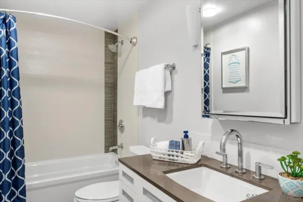 a bathroom with a granite countertop sink toilet and shower