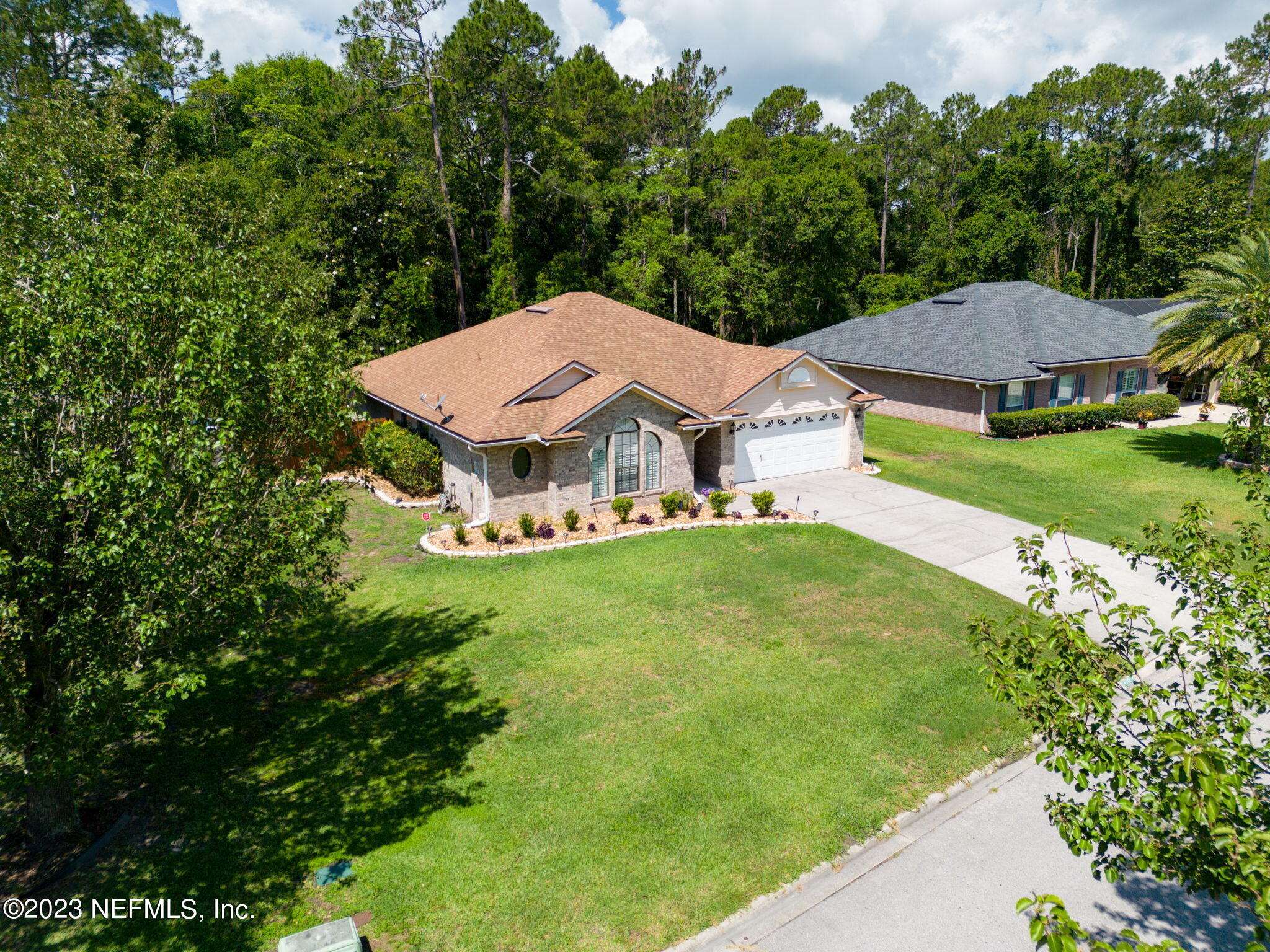 1662 Dockside Drive Fleming Island, FL 32003 - Photo 2 of 18 a view of a house with a yard table and chairs under an umbrella