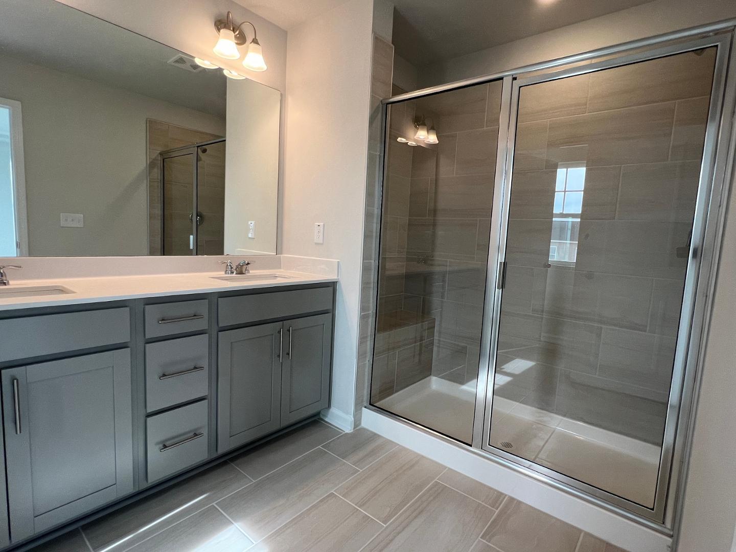 5028 Arkose Drive Raleigh, NC 27610 - Photo 13 of 36 a bathroom with a shower sink and mirror