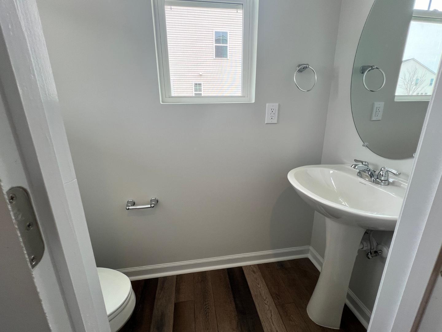5028 Arkose Drive Raleigh, NC 27610 - Photo 8 of 36 a bathroom with a sink a toilet a mirror and a window