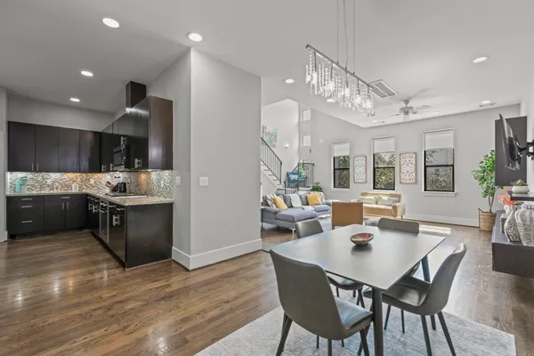 a kitchen with stainless steel appliances kitchen island granite countertop a stove a sink a dining table and chairs