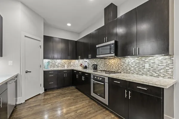a kitchen with stainless steel appliances granite countertop a sink stove and refrigerator
