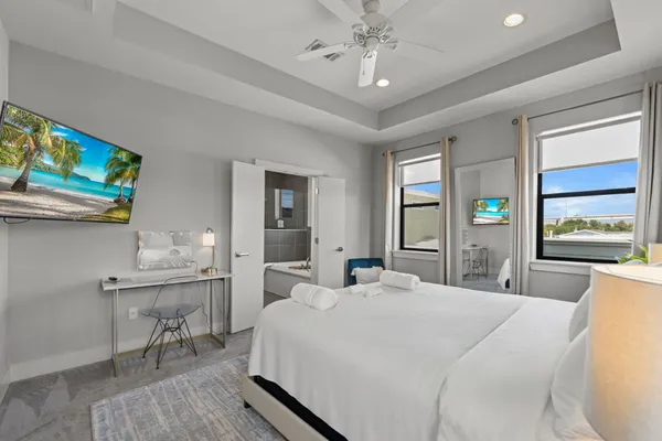 a bedroom with a bed a chandelier and mirror