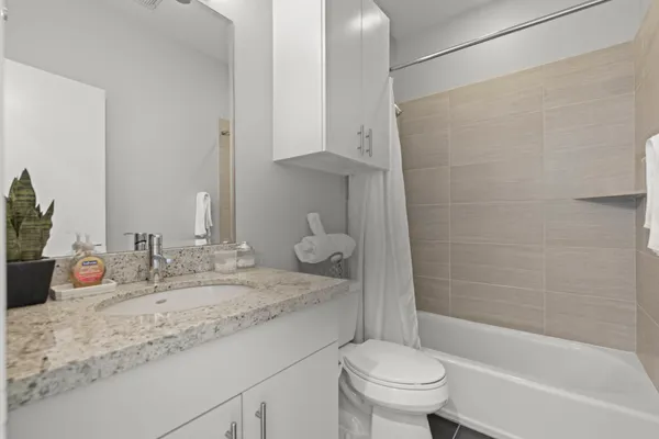 a bathroom with a granite countertop sink toilet and shower