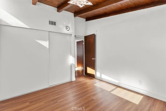 a view of a hallway with wooden floor and a window