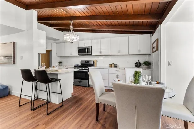 a kitchen with stainless steel appliances granite countertop white cabinets and a stove top oven