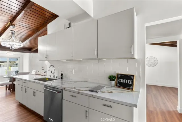 a large white kitchen with stainless steel appliances granite countertop a lot of counter space