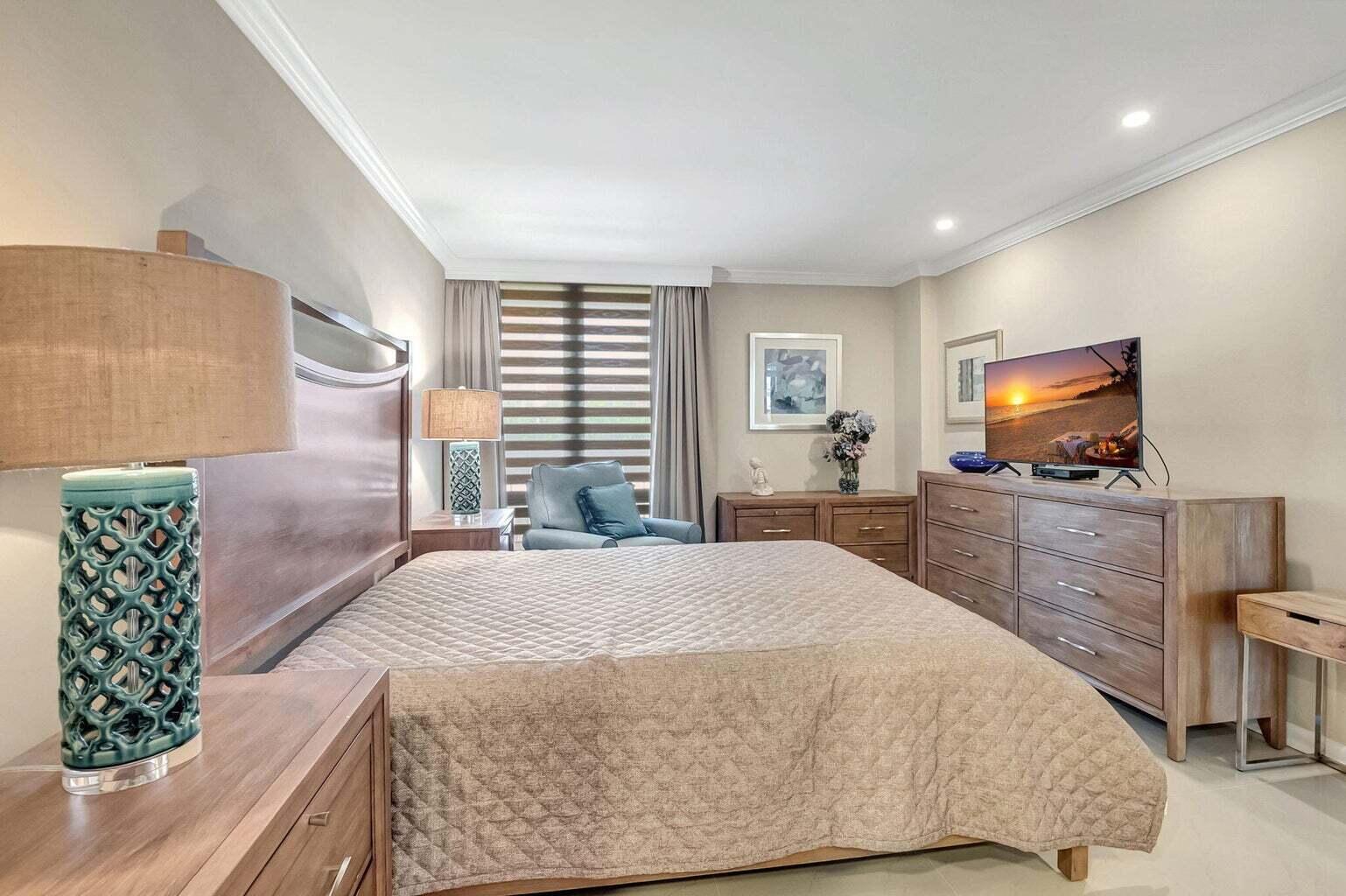 2707 North Ocean Boulevard, Unit D205 Boca Raton, FL 33431 - Photo 24 of 51 a bedroom with a bed and a flat screen tv