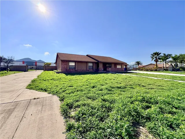 a view of a house with a big yard and large trees