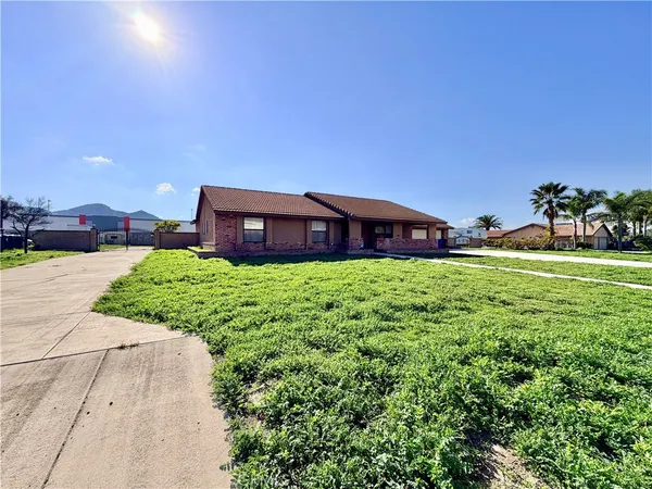 a view of a house with a big yard and large trees