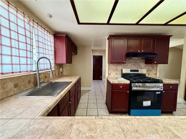 a kitchen with stainless steel appliances kitchen island granite countertop a refrigerator and a sink