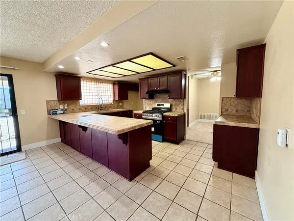 a kitchen with stainless steel appliances granite countertop a stove a sink and a microwave