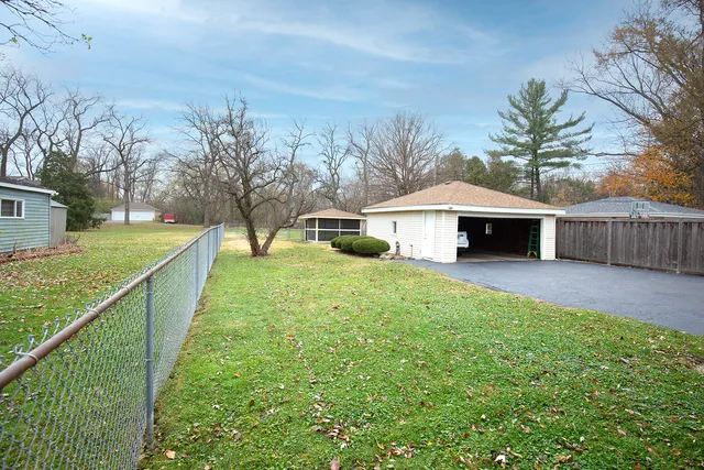 a front view of a house with garden and trees