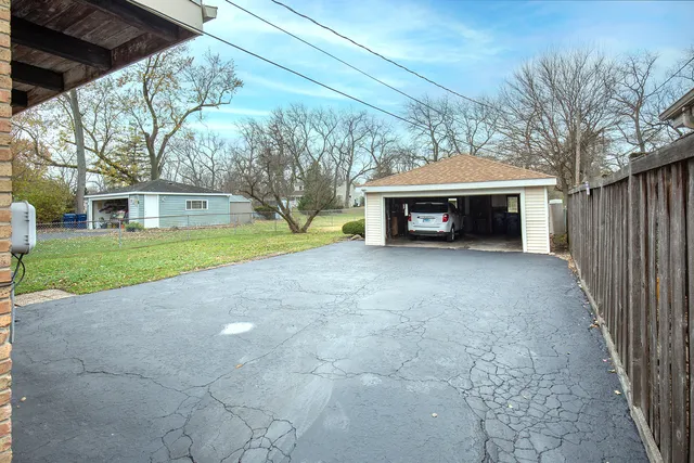 a view of house with outdoor space and large trees