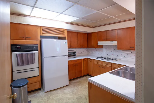 a kitchen with a refrigerator sink and cabinets
