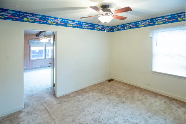 a view of a room with wooden floor and fan