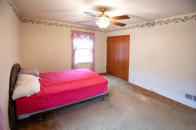 a bedroom with a bed and a chandelier