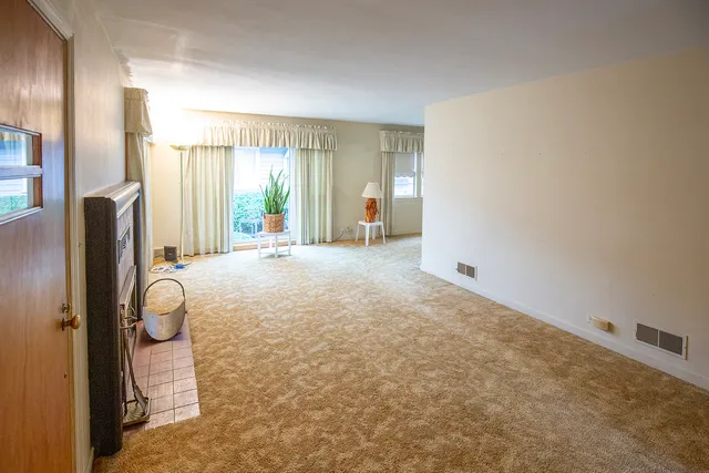 a view of a livingroom with wooden floor and a large window