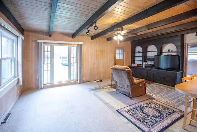 a living room with furniture a flat screen tv and a large window