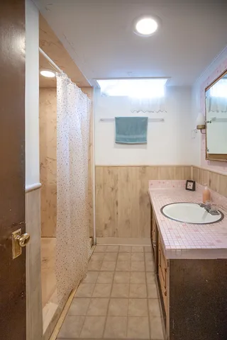 a bathroom with a sink a toilet and a mirror