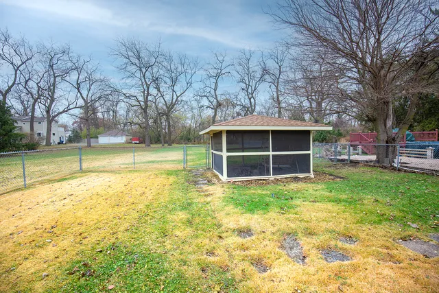 a view of a house with backyard and trees