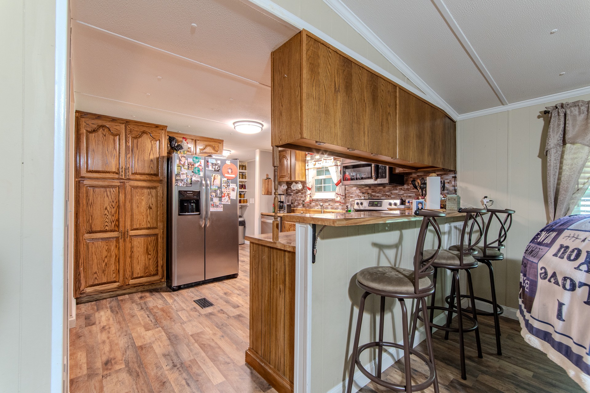 3130 Nance Bend Road Clifton, TN 38425 - Photo 31 of 76 a kitchen with stainless steel appliances granite countertop a refrigerator a stove a sink dishwasher and a microwave oven with wooden floor