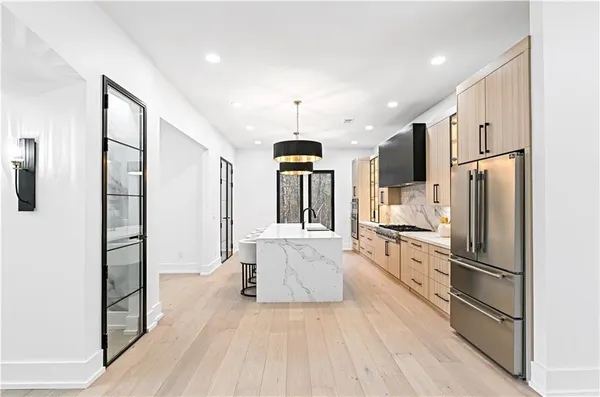 a kitchen with a stove a sink a dining table and chairs with wooden floor